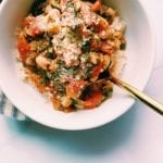 Instant white bean, tomato and spinach stew in a white bowl with a gold spoon