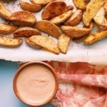 Yummiest potato wedges on a parchment lined baking sheet