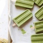 Matcha popsicles on a parchment lined tray
