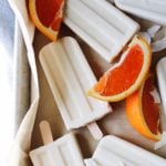 orange coconut milk popsicles on parchment paper