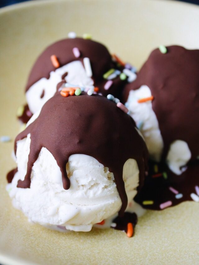 close up of vanilla ice cream scoops with chocolate shell ice cream topping