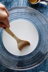 sourdough starter and warm water being mixed in a bowl