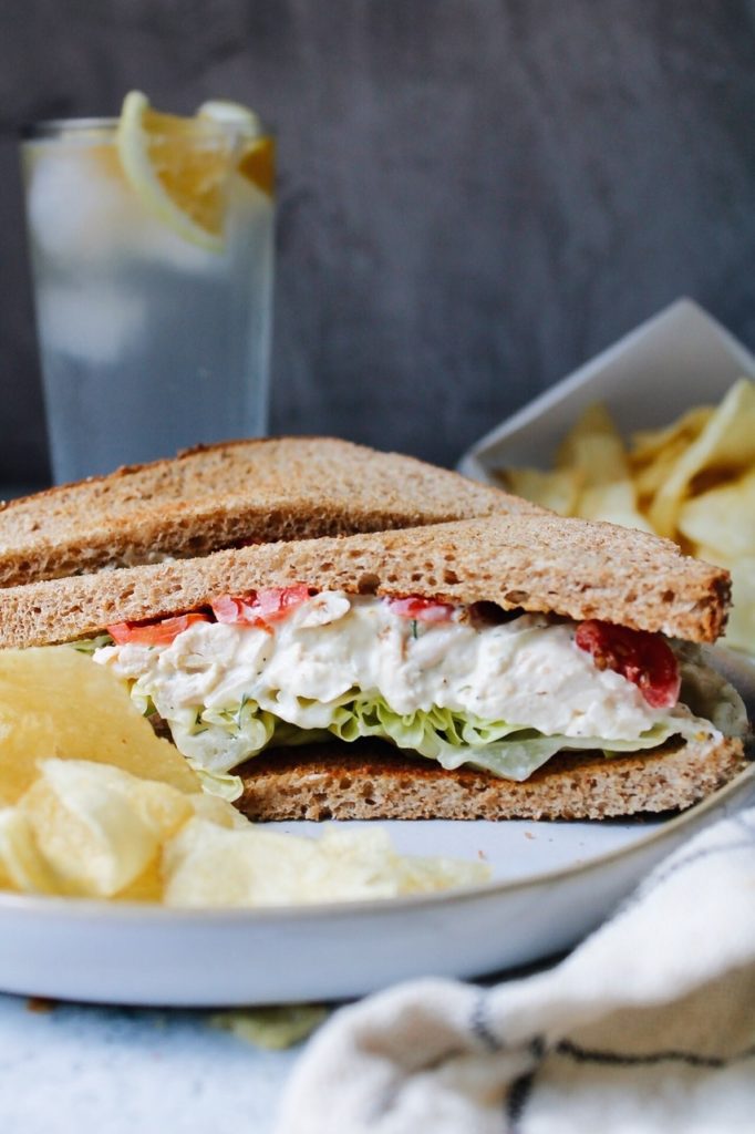 chicken salad sandwich on a plate with chips. 