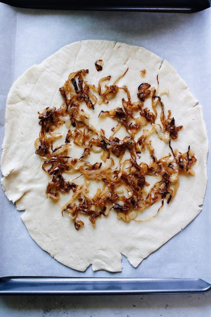 caramelized onions arranged on top of pie crust