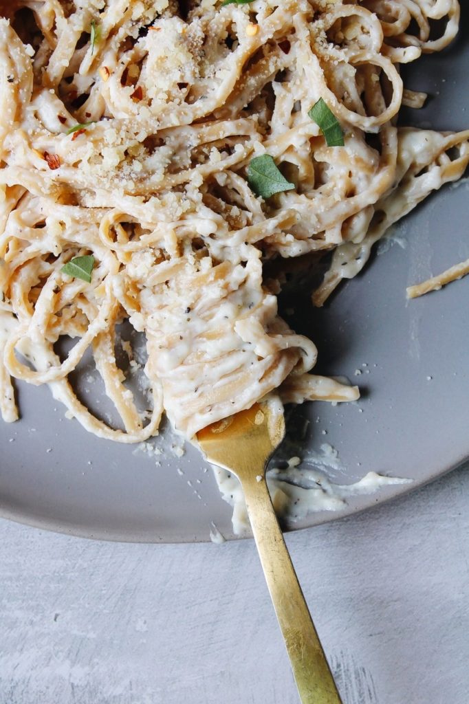 close up of fettuccini alfredo made without heavy cream twirled around a fork. 