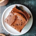 sourdough chocolate cake on a plate next to a cup of coffee