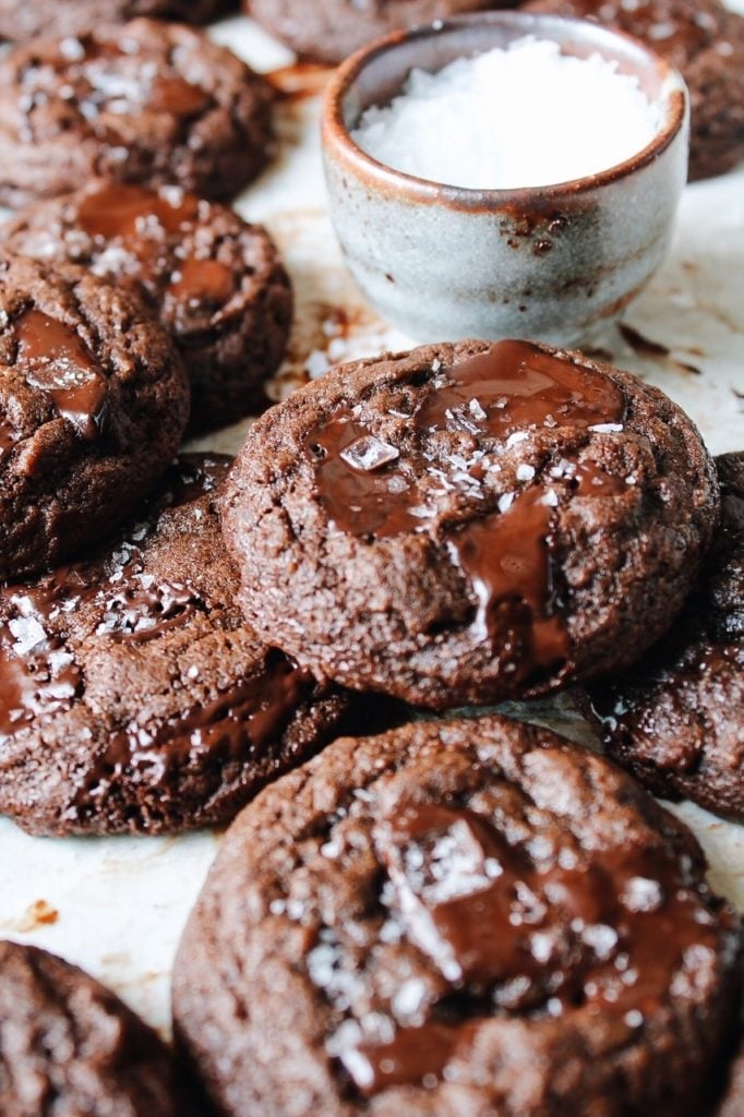Double chocolate cookies stacked on a baking sheet with parchment paper