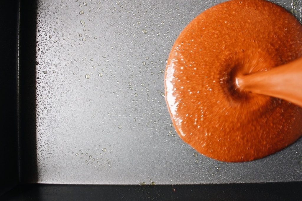 cake batter being poured into a cake pan