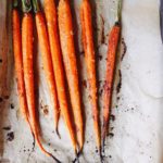 roasted carrots with honey, ginger and garlic on a baking sheet