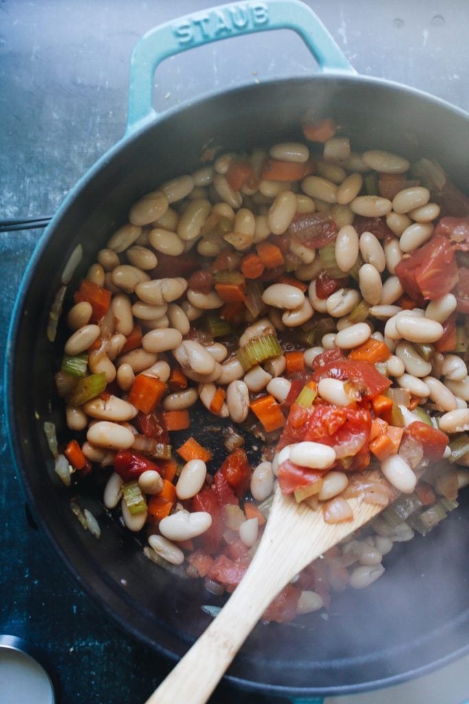 vegetable soup being made in a dutch oven.