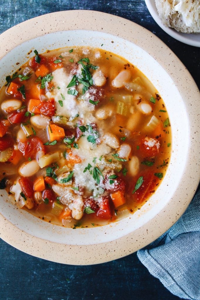 vegetable white bean soup topped with parmesan and parsley