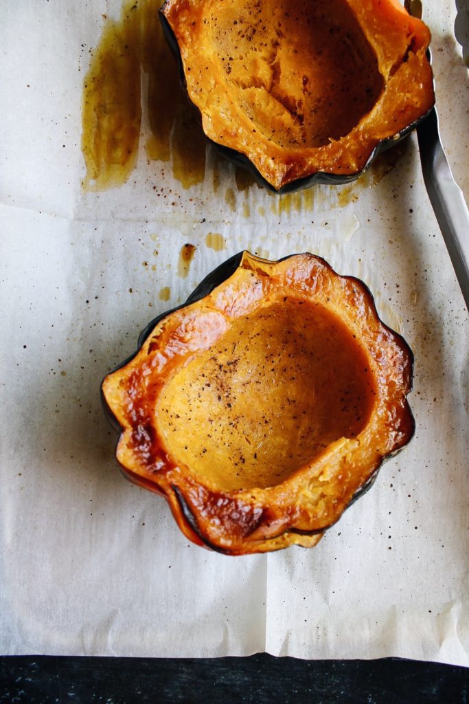 roasted acorn squash on a baking sheet line with parchment