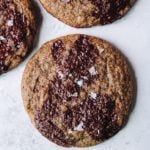 buckwheat chocolate chip cookies topped with sea salt on a white background