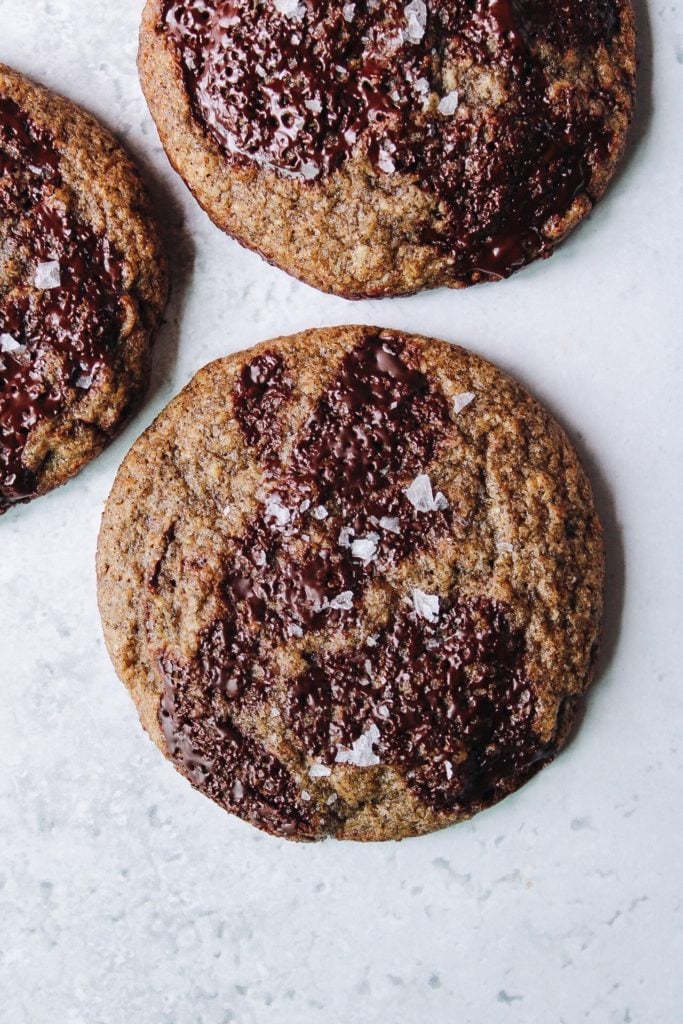 buckwheat chocolate chip cookies topped with sea salt on a white background