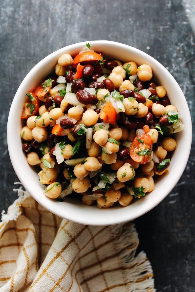 chickpea and black bean salad in a bowl on a dark background