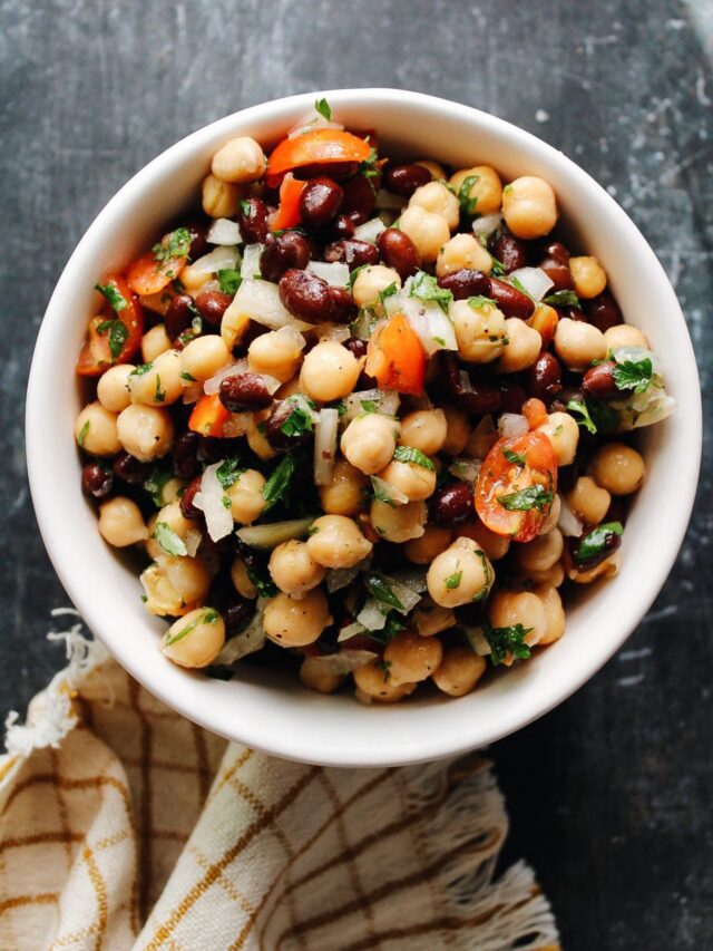 chickpea and black bean salad in a bowl on a dark background