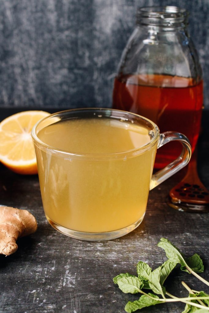 ginger mint tea with lemon in a clear glass mug