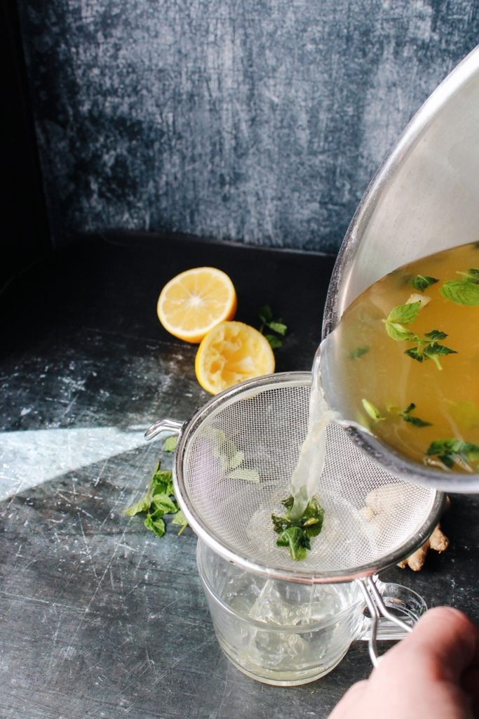 ginger mint tea being strained into a mug