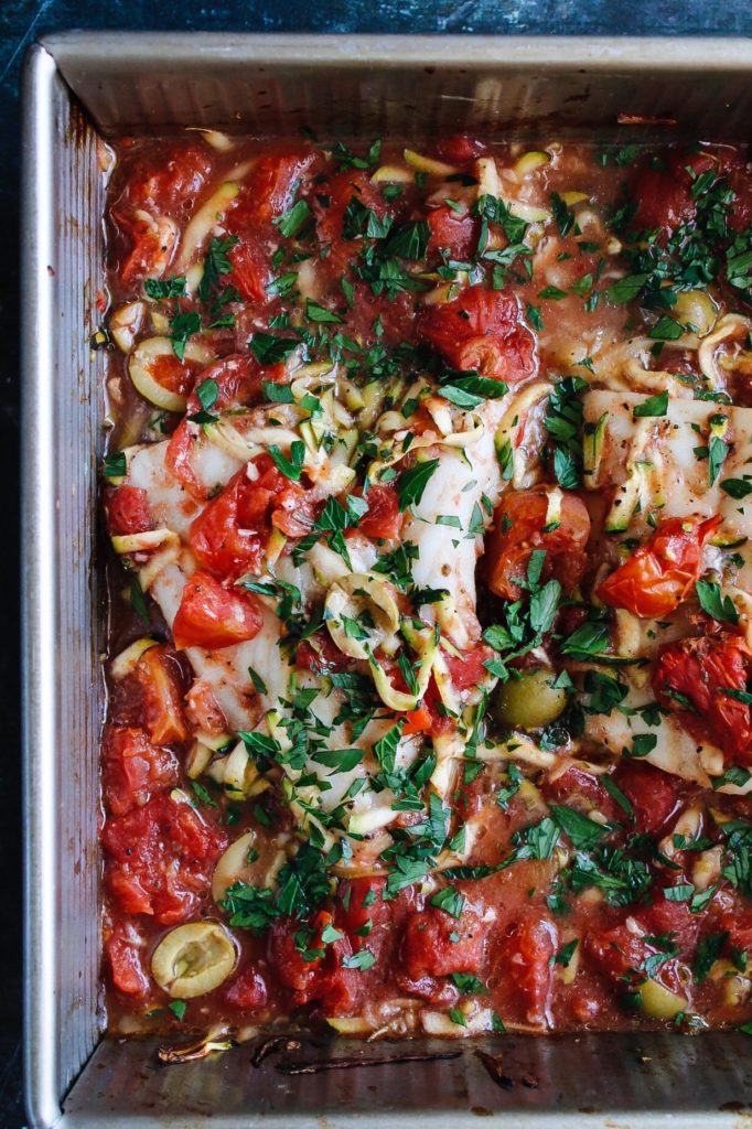 italian baked white fish with tomatoes in baking dish
