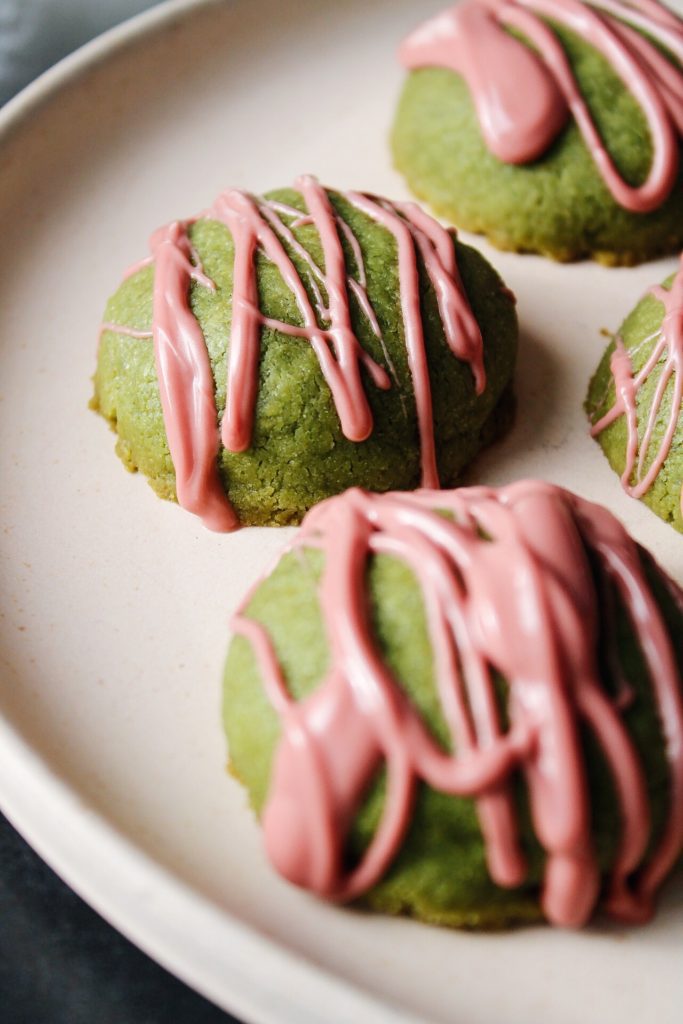 matcha shortbread cookies with ruby chocolate drizzle on a plate