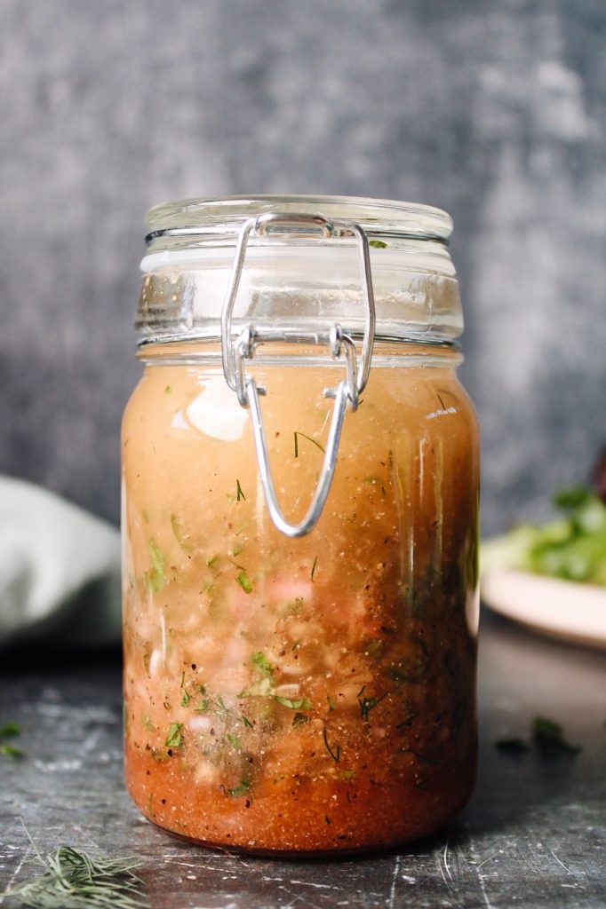 red wine shallot vinaigrette in a glass jar next to salad