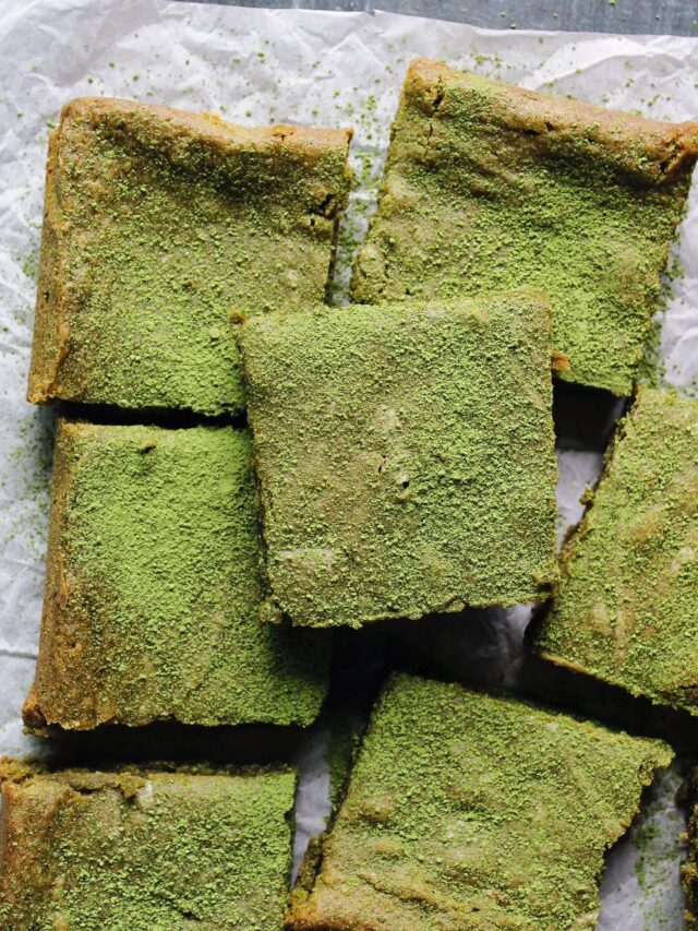 matcha brownies dusted with matcha green tea powder on parchment paper