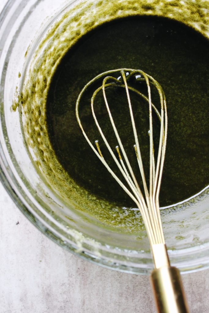 melted white chocolate, butter and matcha whisked together in a bowl for matcha brownie recipe