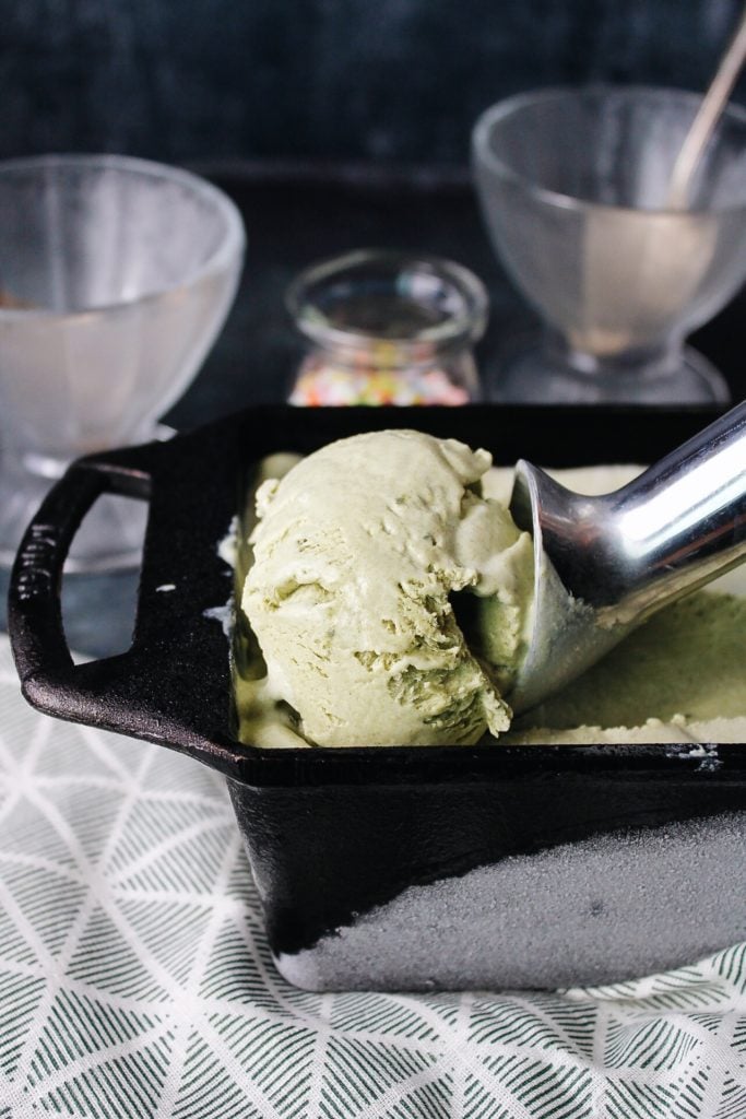 matcha ice cream being scooped out of a loaf pan