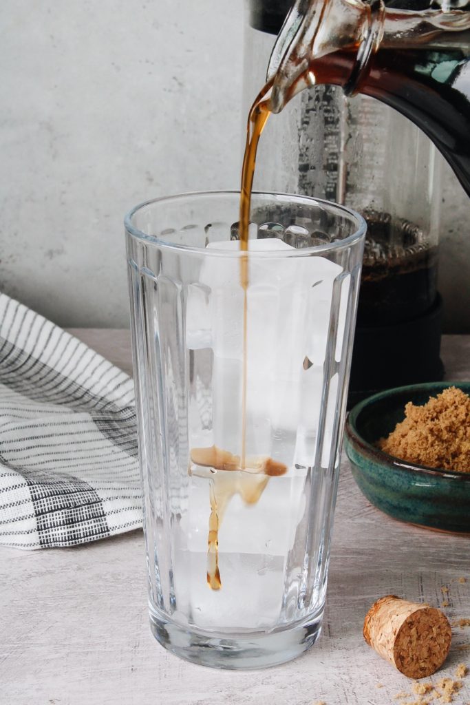 brown sugar syrup being poured over ice to make a latte