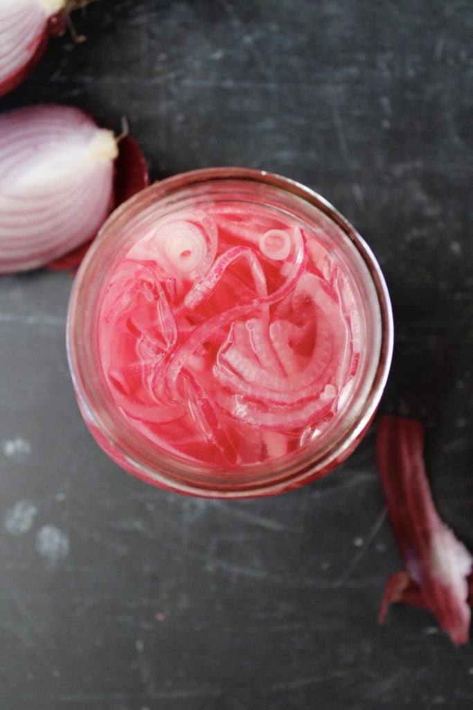 pickled red onions in a glass jar