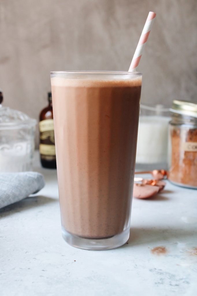 glass of homemade chocolate milk with a pink and white striped straw