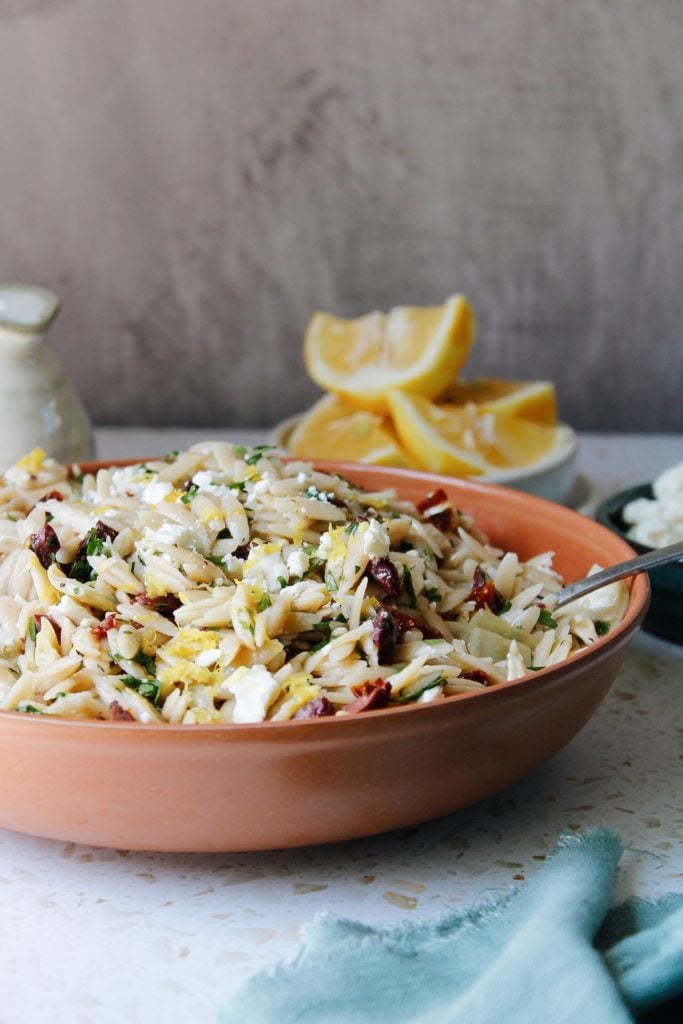 lemon orzo pasta salad in a red bowl 