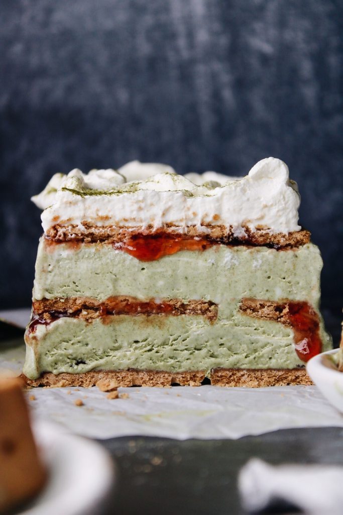 matcha cheesecake sliced to reveal layers of graham crackers, jam and matcha filling