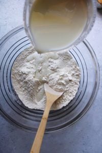 milk being poured onto dry ingredients for peanut butter bread