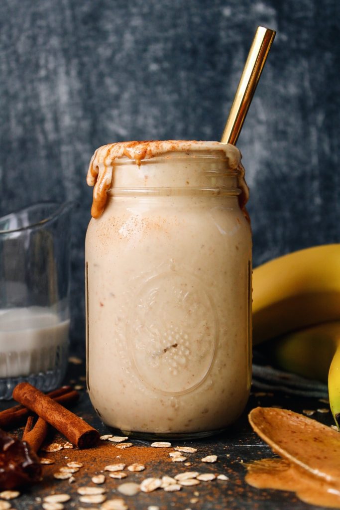 oat milk banana date peanut butter smoothie in a glass jar