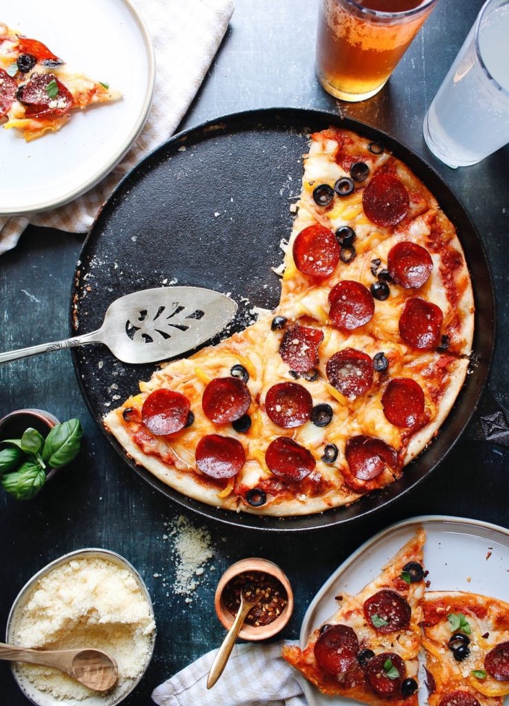 a pizza made with sourdough discard crust topped with pepperoni and olives