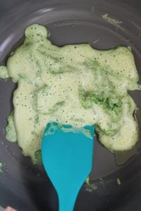 spinach eggs in the middle of cooking with foamy egg liquid on top