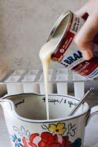 sweetened condensed milk being poured into earl grey tea