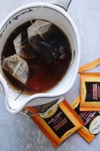 3 earl grey tea bags brewing in boiling water