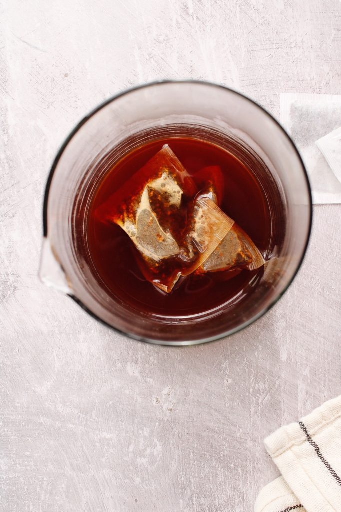 two chai tea bags steeping in hot water