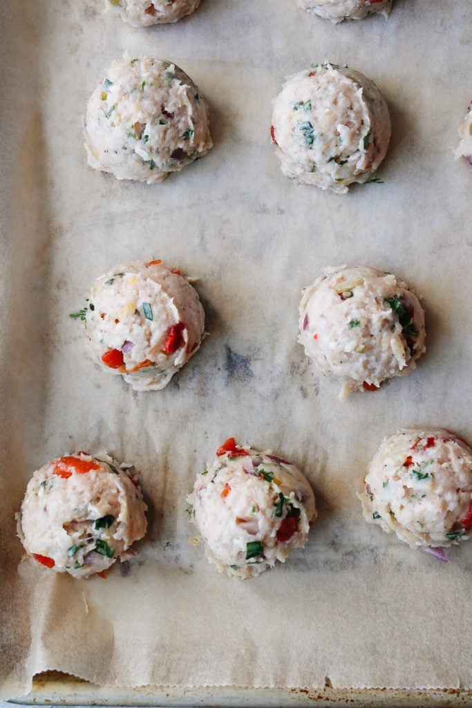 greek chicken meatballs on a baking sheet lined with parchment paper