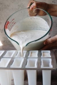 earl grey popsicle mixture being poured into popsicle molds