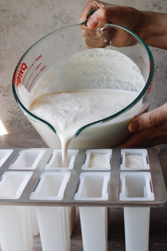 earl grey popsicle mixture being poured into popsicle molds