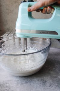 heavy whipping cream being beaten with an electric mixer