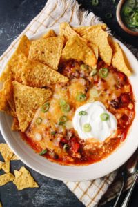 southwest chicken chili topped with cheese, sour cream, green onions and tortilla chips