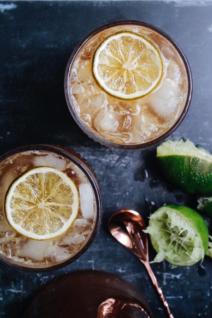 chai lime fizzy drink in clear glasses garnished with a candied lime slice