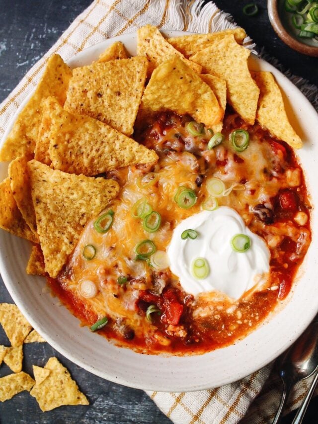 southwest black bean chicken chili topped with cheese, sour cream, green onions and tortilla chips