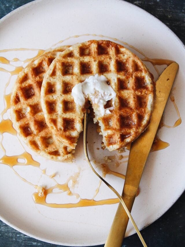 oat flour waffles on a beige plate with butter and syrup