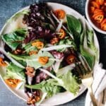 Roasted kumquat salad with candied pecans and cheese on a plate