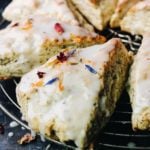 side view of earl grey scones with vanilla bean icing on a circular cooking rack